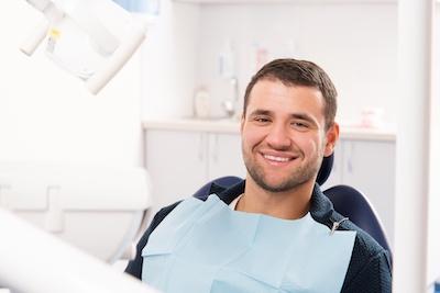 man smiling in dental chair after emergency appointment