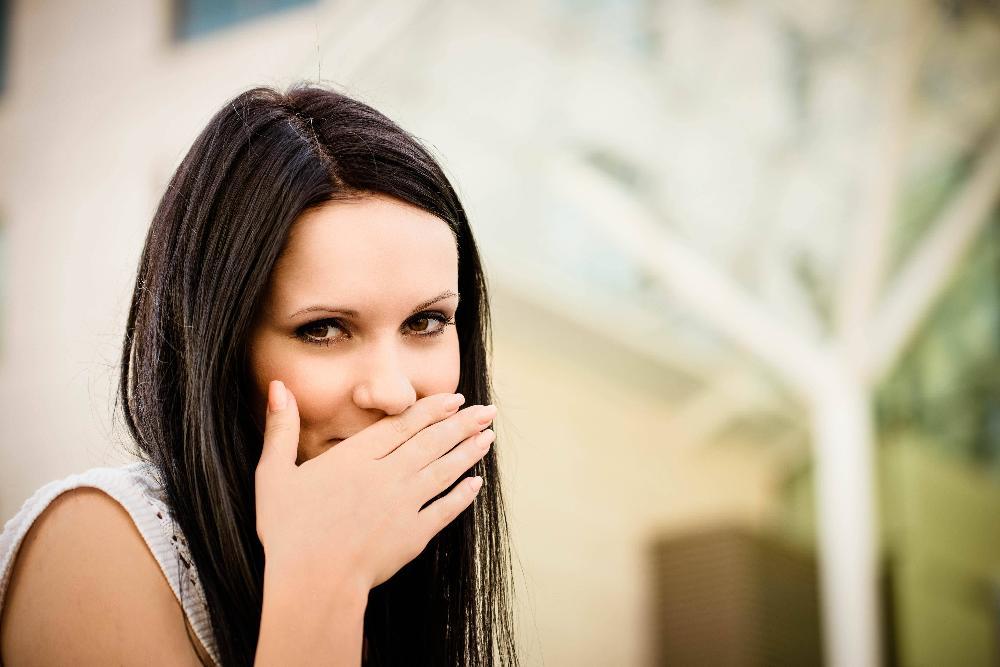 woman holding hand in front of mouth