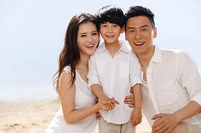 Son, mother, and father smiling on beach