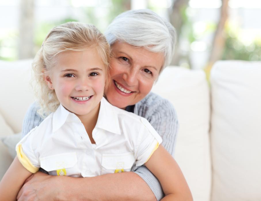 Little girl standing in front of her grandma