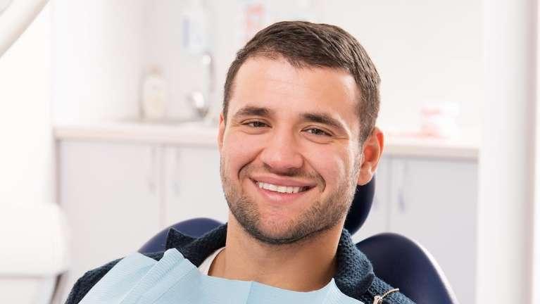 Man smiling in dental chair during an exam